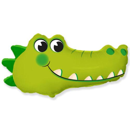 Image is of a large foil balloon, in the shape of a crocodile's head.  The balloon is green in colour with three dark green triangles on the left.  The crocodile has two large eyes and a large toothy grin.