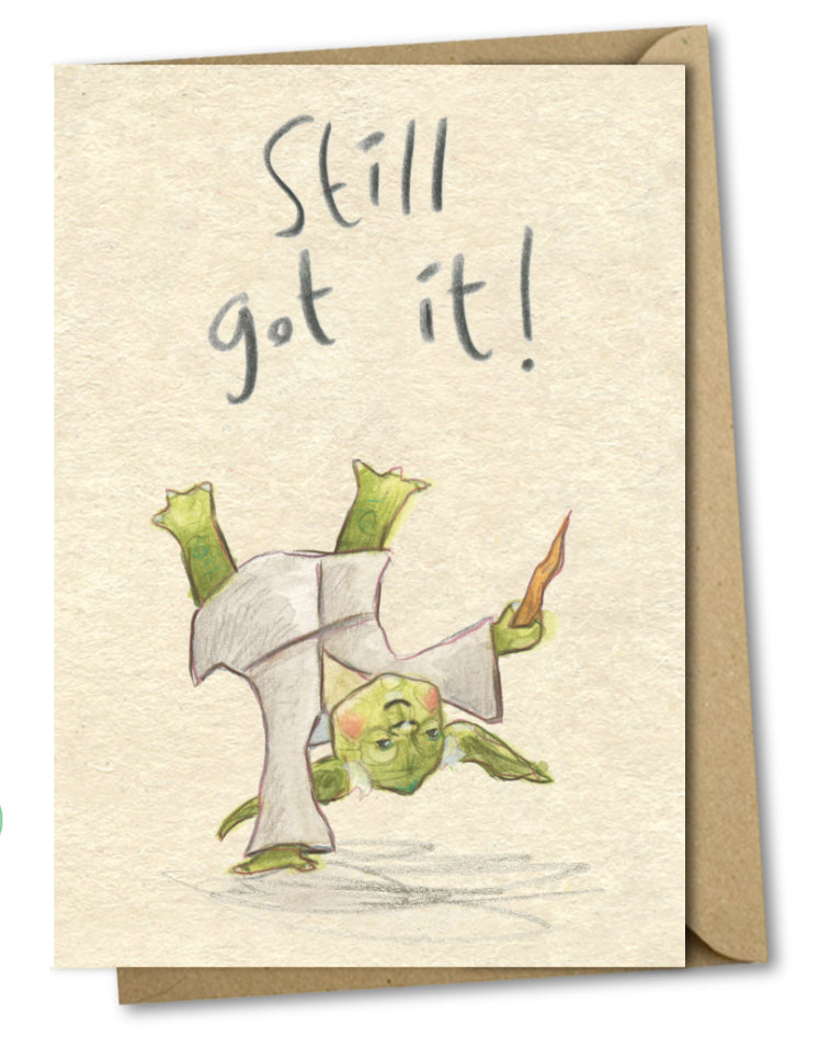 A greetings card with a mottled beige background and handwritten words above the illustration saying 'still got it!'. The illustration is of yoda from the movie star wars doing a breakdancing move or cartwheel.