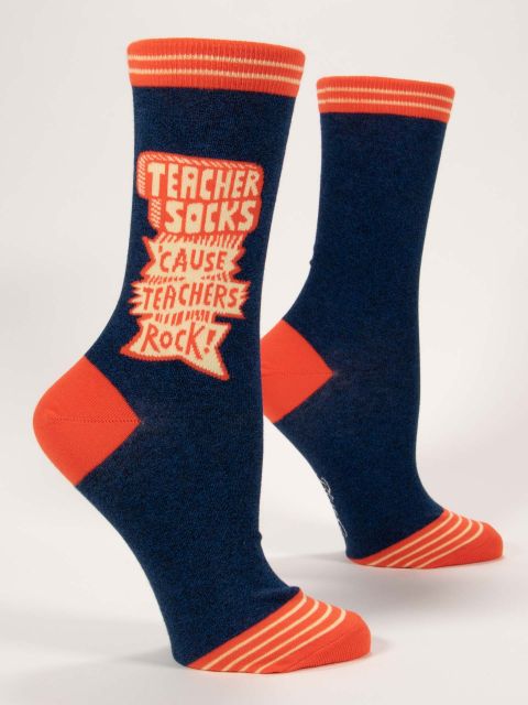A pair of navy socks with bright orange toes, heel and top edge. There is big text down each outer edge saying Teacher socks &#39;cause teachers rock!