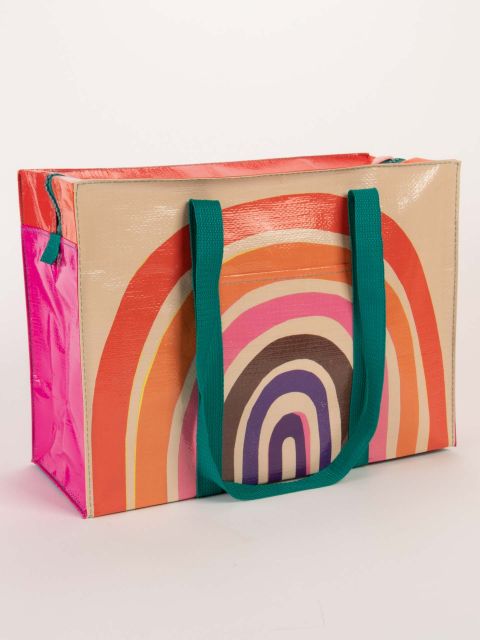 A large multicoloured shoulder tote bag with a teal handles and a large retro style rainbow design.