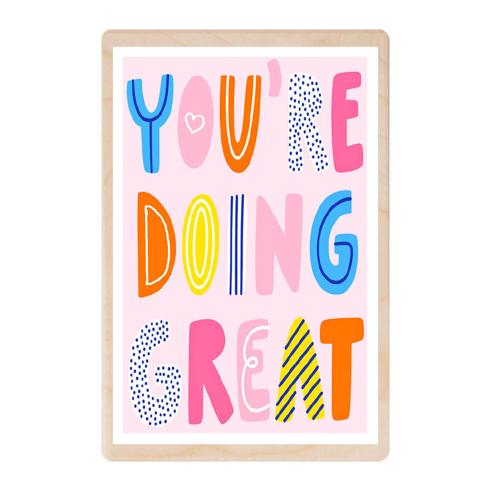 A wooden postcard featuring giant words 'You're Doing Great'. The letters are uniquely different to eaach other and in different colours, all block capitals.