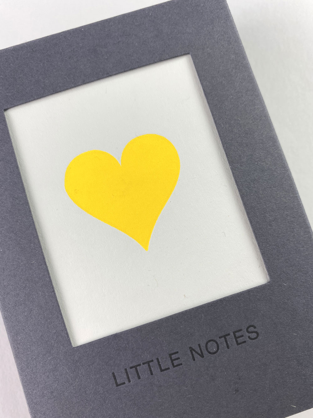An image of a pack of notecards with a cream background and a large yellow heart in the centre.