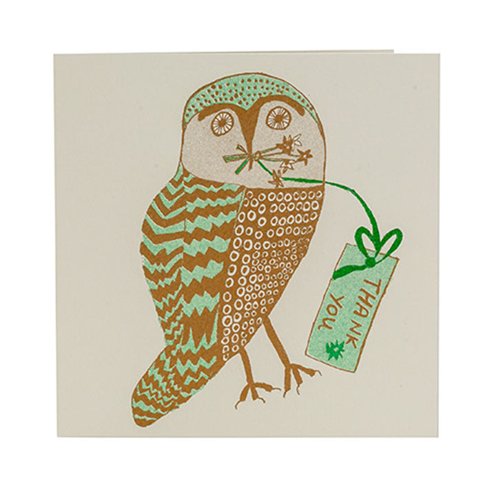 A greetings card with an illustration of an owl in brown and green. The owl is holding a note in it's mouth with the words 'thank you' on it.