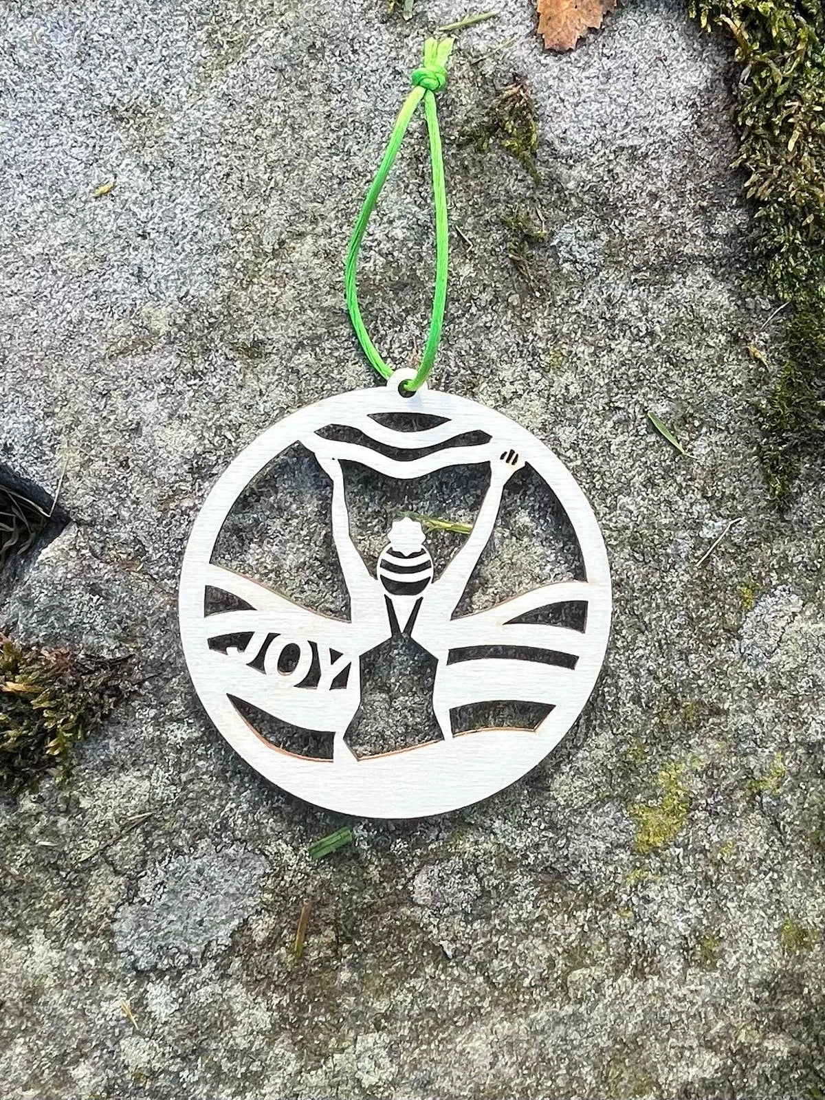 Wild Swimming Wooden Hanging Decoration by penny black, shown on a beach