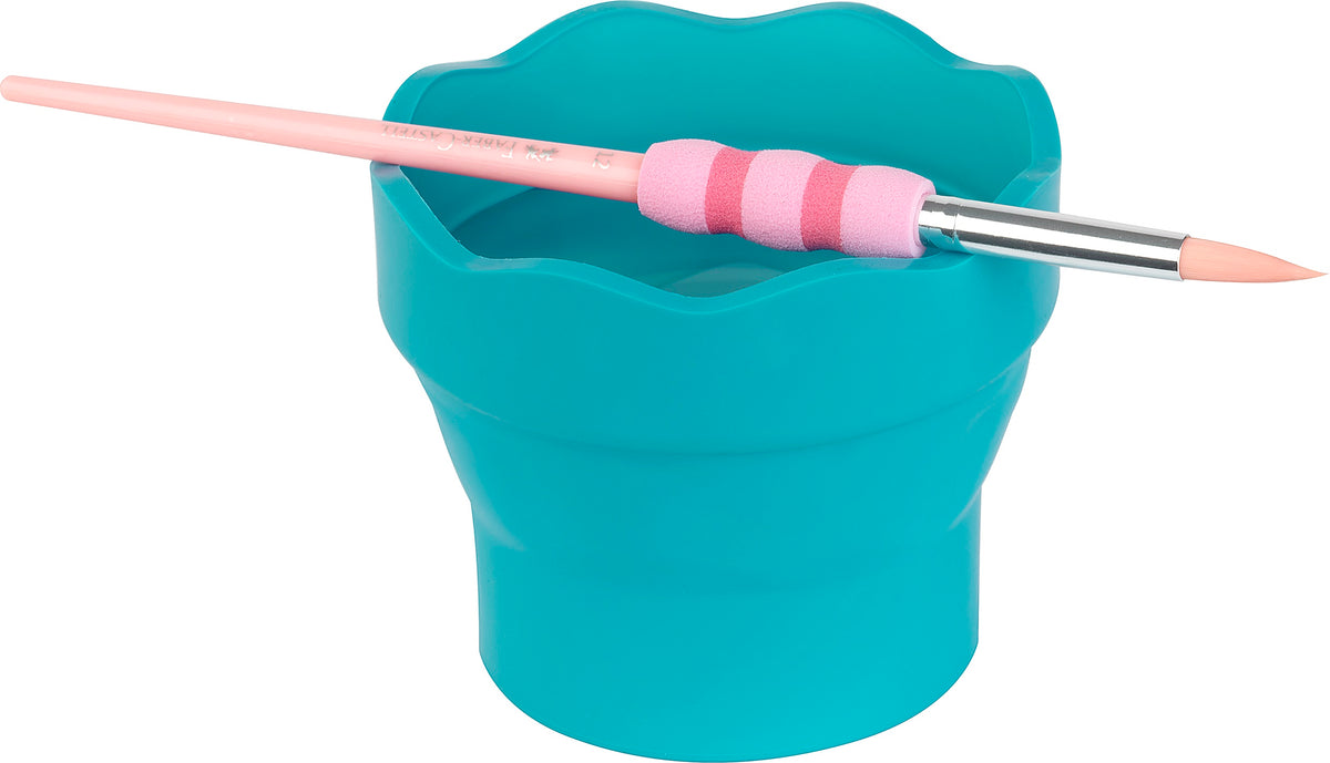 An image of a turquoise foldable water cup in action, with a paintbrush resting on top.