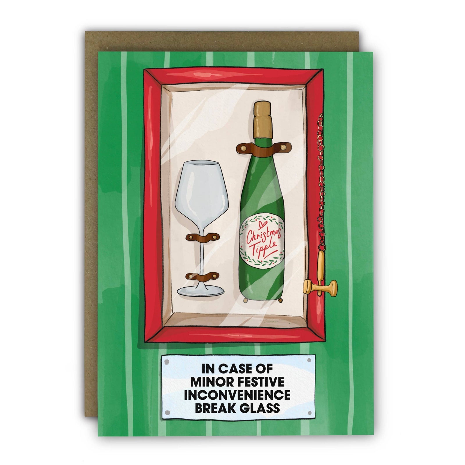 A christmas card with a green striped border and a brown envelope behind it. The card features an illustration of a green champagne bottle and a wine glass inside a red-framed wall niche, with the text 'IN CASE OF MINOR FESTIVE INCONVENIENCE BREAK GLASS' on a white label at the bottom.