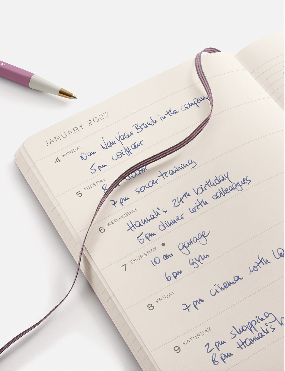 leuchtturm1917 planner with handwritten January 2027 schedule on a white background showing a pen and page marker in dusty rose.