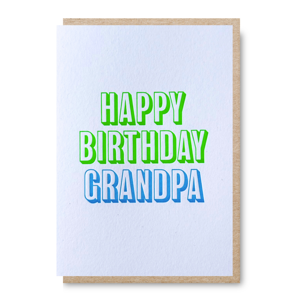 An A6 letterpress printed birthday card with a white textured front and a natural kraft envelope, featuring the text 'HAPPY BIRTHDAY GRANDPA' in bright green and blue lettering.
