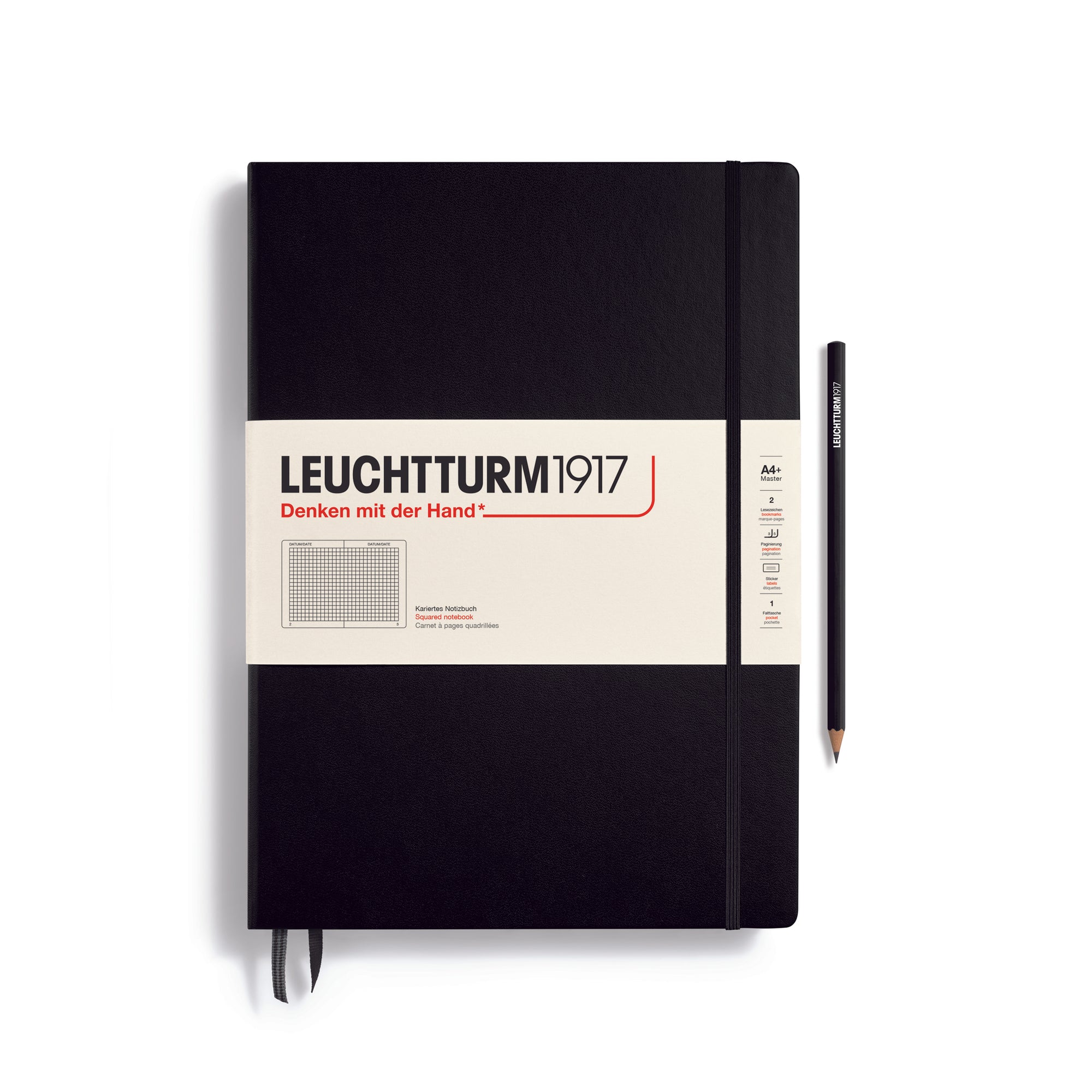 A large black notebook with a white paper band around it with the logo of the brand Leuchtturm1917. Below this is an image of the page ruling inside - in this case, squared. It has two page marker ribbons showing at the bottom near the binding and an elastic notebook closure holding it neatly together. A black Leuchtturm pencil is shown at the side of the book.