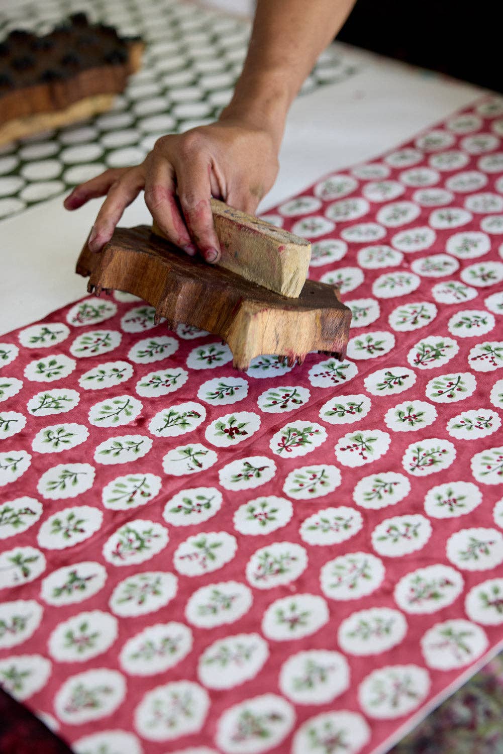 a person hand block printing some christmas wrapping paper.
