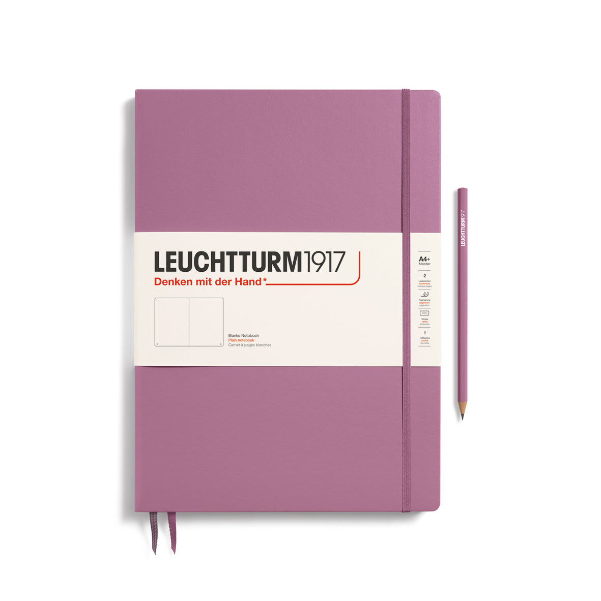 A large dusty rose colour notebook with a white paper band around it with the logo of the brand Leuchtturm1917. Below this is an image of the page ruling inside - in this case, plain. It has two page marker ribbons showing at the bottom near the binding and a matching colour elastic notebook closure holding it neatly together. A dusty rose colour LEUCHTTURM1917 pencil is shown at the side of the book for size reference.
