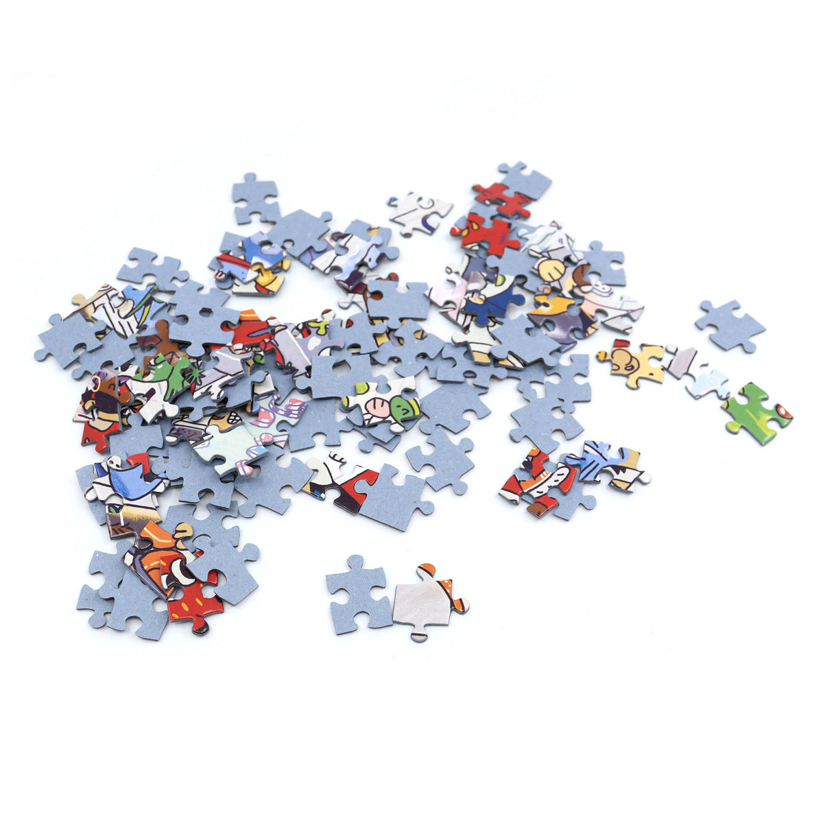 A scattered pile of jigsaw puzzle pieces on a plain white background, with many pieces showing light blue edges and others displaying colourful cartoon-style illustrations.