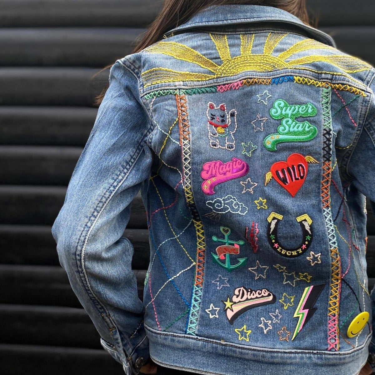 Colourful Iron on Patch - soy sauce fish bottle by penny black showing back of denim jacket with lots of patches