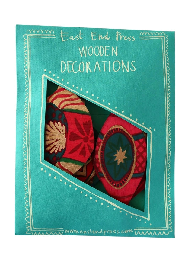 A turquoise package with a cut out showing vintage bauble decorations made from wood. The package states the product is made by East End Press.
