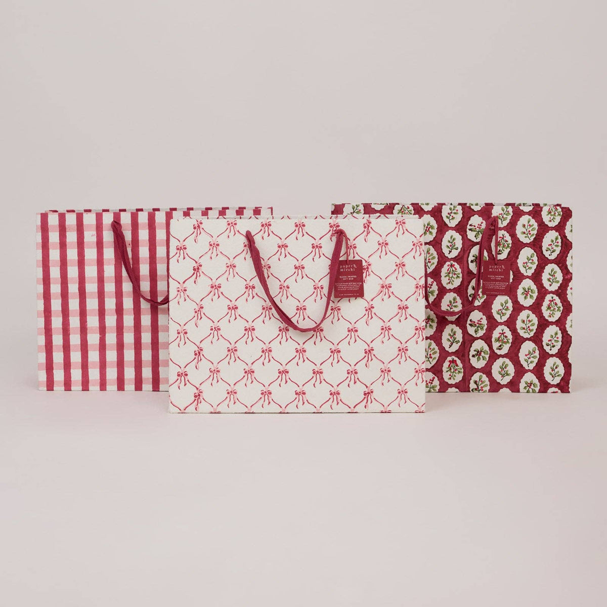 Three patterned christmas gift bags on a light gray background by paper mirchi at penny black