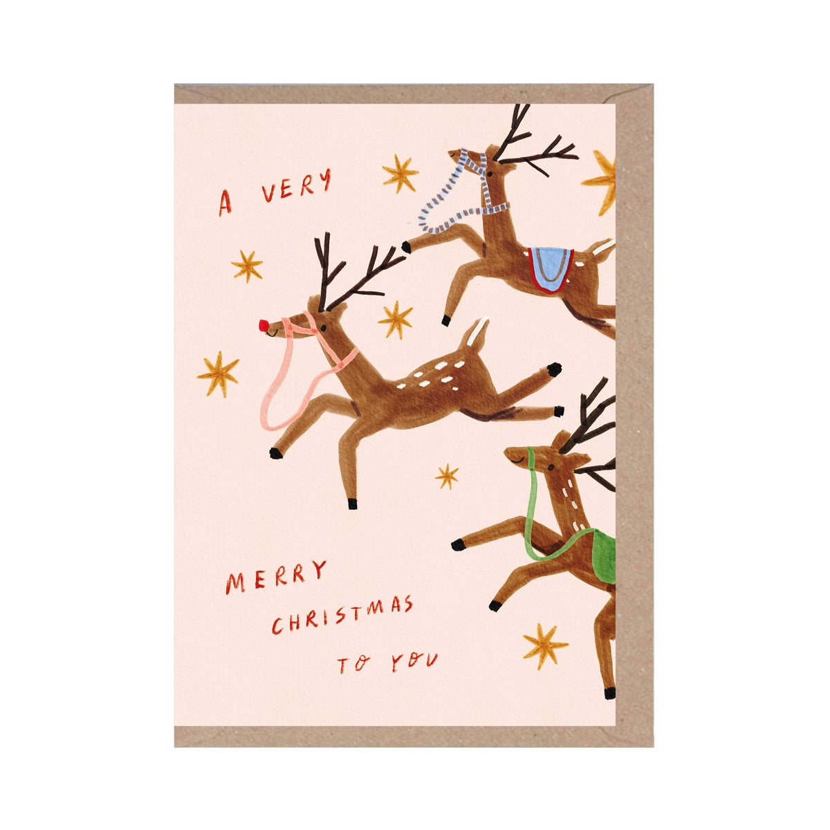 A Christmas greeting card with a kraft envelope, featuring an illustration of three brown reindeer with antlers and colourful harnesses on a pale pink background, with the text 'A VERY Merry Christmas TO YOU'.