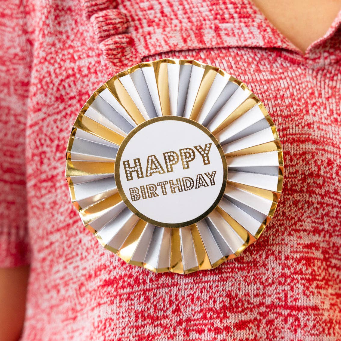 Luxe Gold Happy Birthday Badge pinned on a persons red jumper.