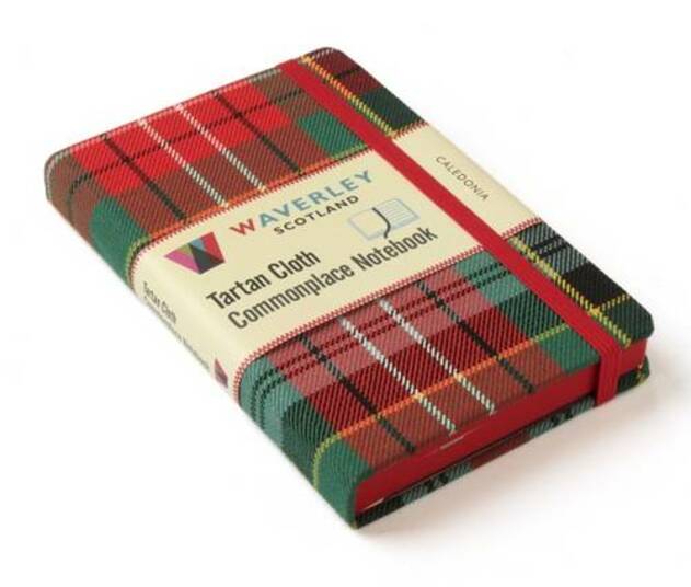 An image of a red and green tartan notebook. It has a red closure band and a paper belly band explaining the product and brand.