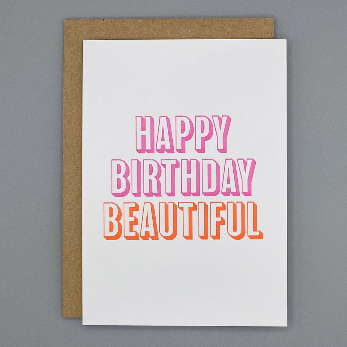 Letterpress birthday card with 'Happy Birthday Beautiful' bold block pink and orange text on a cream background