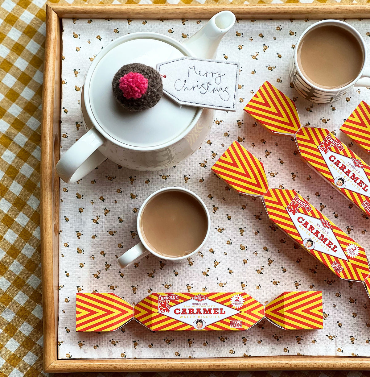 Tunnock's Caramel Wafer Biscuit Christmas Cracker by penny black shown beside a teapot and teacups