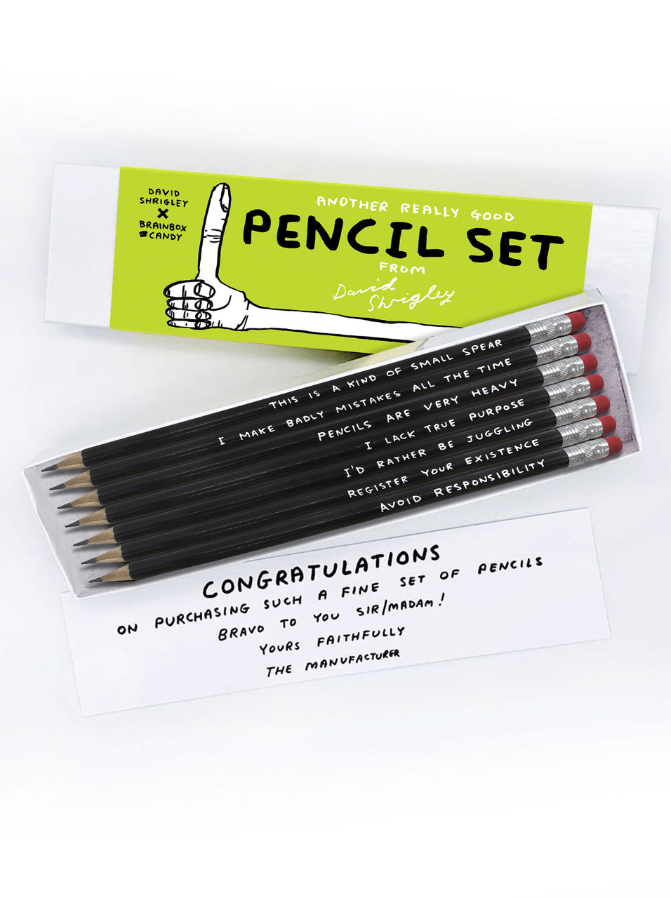 An image of a box of pencils by artist DAvid Shrigley. The box is white with a lime green card band to hold it together. It shows the name of the product and a thumbs up artwork. The pencils are black with white capital hand written words on each and they have a rubber at one end.