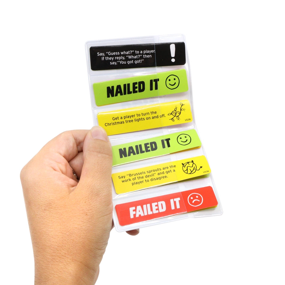 A hand holding a clear plastic sleeve containing five rectangular cards with phrases and emoji faces, shown against a plain white background.