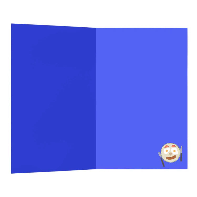 A royal blue open greetings card with a small illustrated plate with smiley face made out of food in the bottom right hand corner.