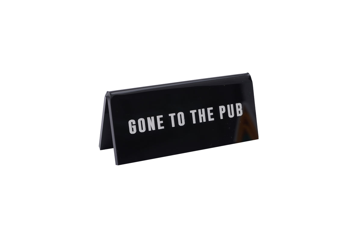A small BLACK acrylic sign that has in big white capital letters on it &#39;GONE TO THE PUB&#39;.