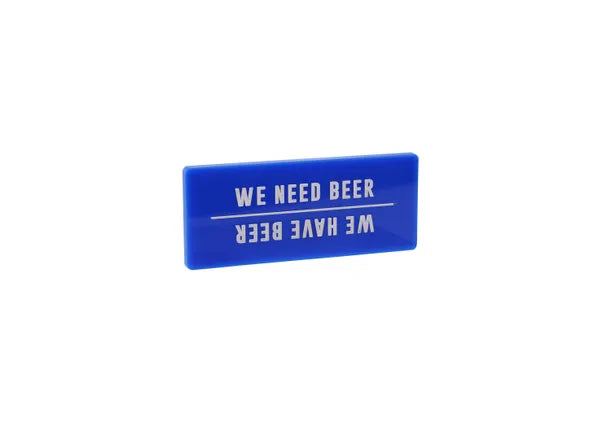 A rectangular blue fridge magnet with the words WE HAVE BEER in white capitals. And if you turn it upside down it reads WE NEED BEER, separated by a thin white line.