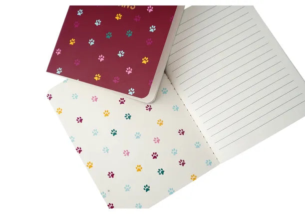 An image showing the inside of two notebooks, both of which have ruled paper for writing on and cat paw prints on the inside covers.