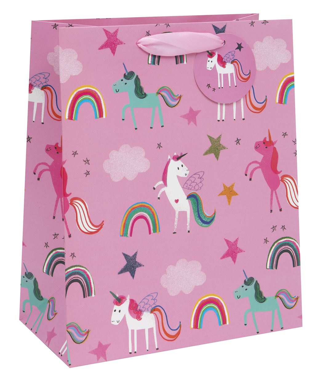 A pink gift bag with varying coloured unicorns in different standing or prancing positions - some are white, some pink or turquoise. Rainbows, clouds and stars also feature. There is a pink ribbon handle and a pink gift tag attached to it with a white winged unicorn image on it.