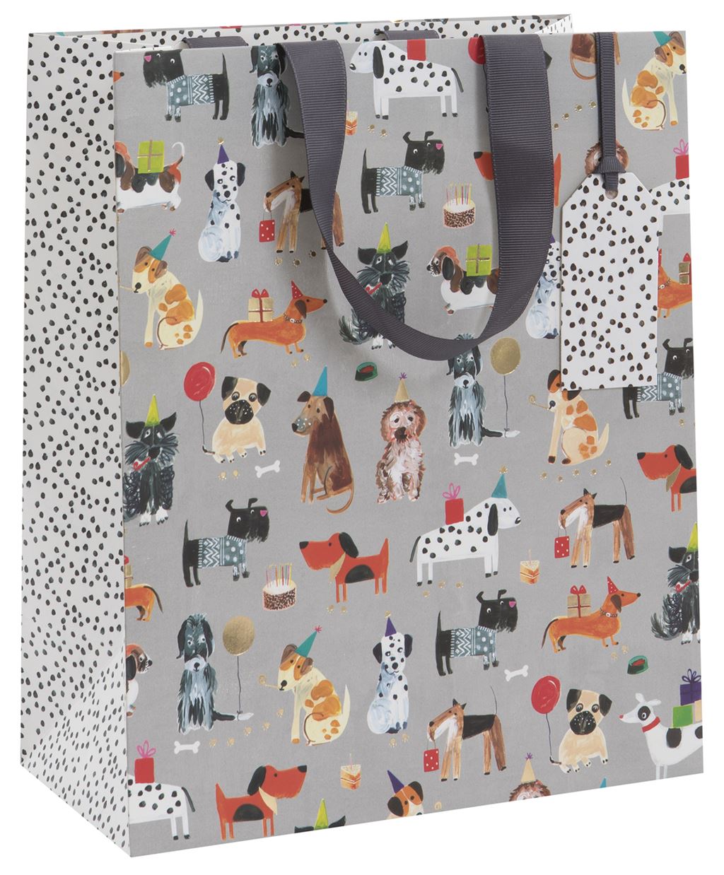 A gift bag with a medium grey background covered in illustrated different breeds of dog - some with party hats, balloons or gifts. The sides and gift tag on the bag have a white background and are covered in small black spots like a Dalmatian. There in a dark grey ribbon handle.