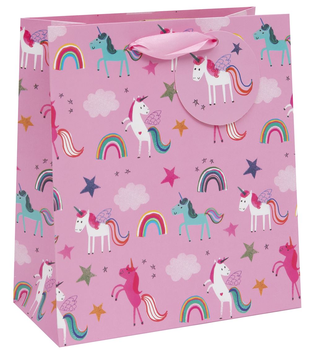 A pink gift bag with varying coloured unicorns in different standing or prancing positions - some are white, some pink or turquoise. Rainbows, clouds and stars also feature. There is a pink ribbon handle and a pink gift tag attached to it with a white winged unicorn image on it.