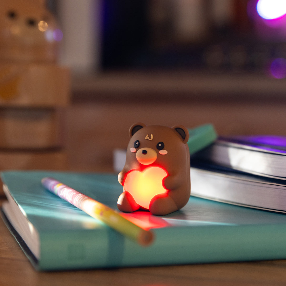Legami Light Up Teddy Bear Pencil Sharpener by penny black shown on a desk lit up