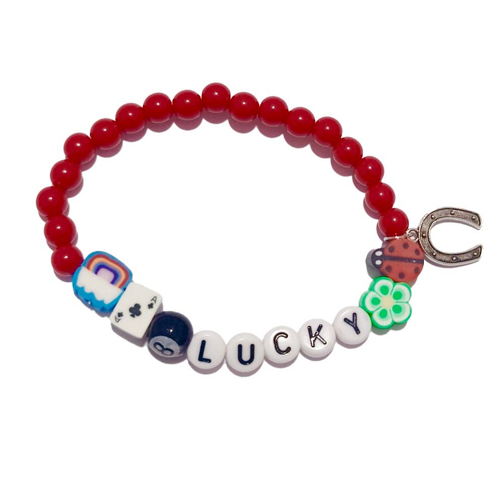 Bracelet with red beads and various lucky charms on a white background.