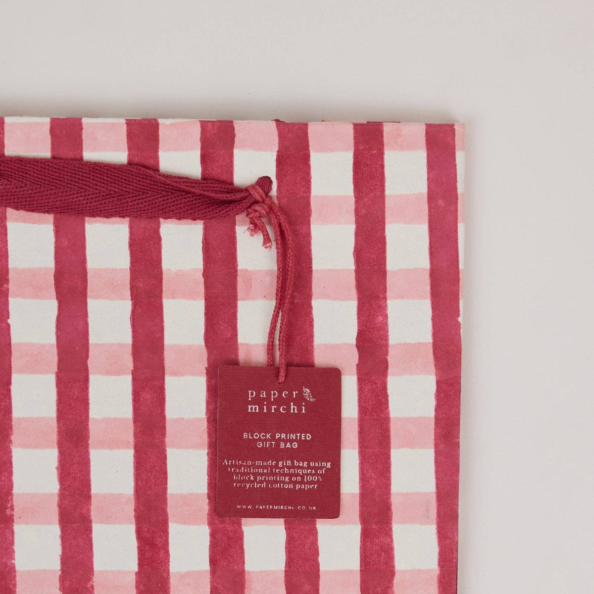 Close up of a Pink and red plaid design block printed gift bag by paper mirchi and penny black