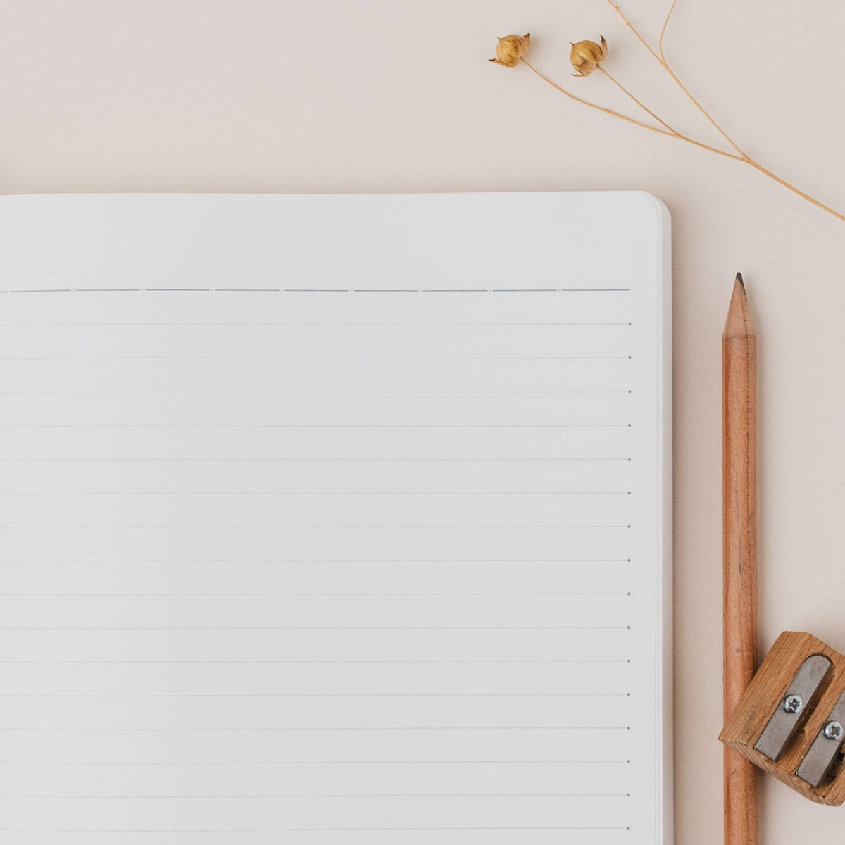 Loch Lomond A5 Scottish Ruled Notebook showing inside ruling whilst open on a table with a pencil and sharpener