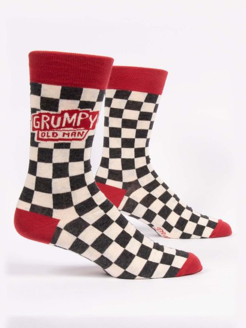 A pair of checkerboard black and white socks with red toes, heels and top edge. In red and white writing each sock on the outer edge says &#39;grumpy old man&#39; in an Americana style.