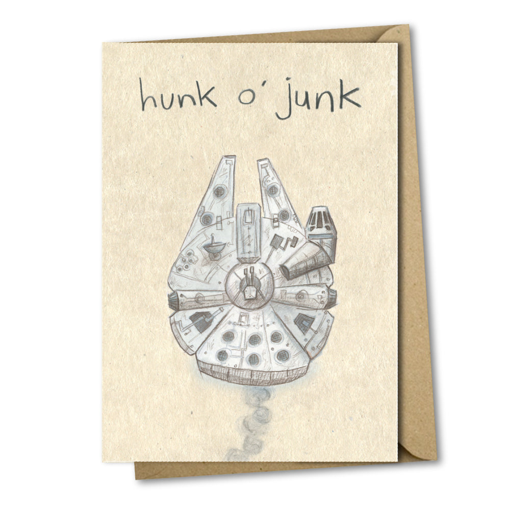 A greetings card with a mottled beige background and the words handwritten above an illustation stating &#39;hunk o&#39; junk&#39;. The illustration is of a white and grey spaceship from Star Wars. There is smoke coming out of the ship as if it&#39;s struggling.