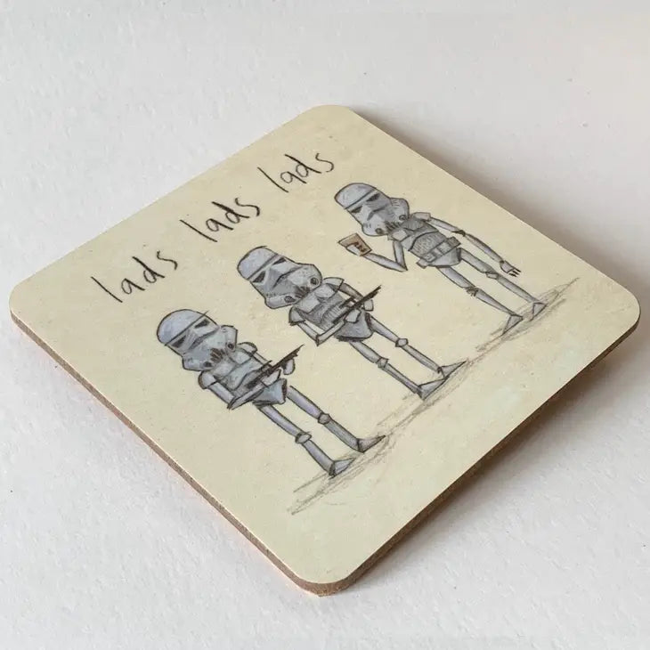 A drinks coaster with a cream background showing 3 white stormtroopers and the words &#39;lads lads lads&#39; handwritten above them. Two stormtroopers are holding black guns and pointing them at the third who is holding a drink.