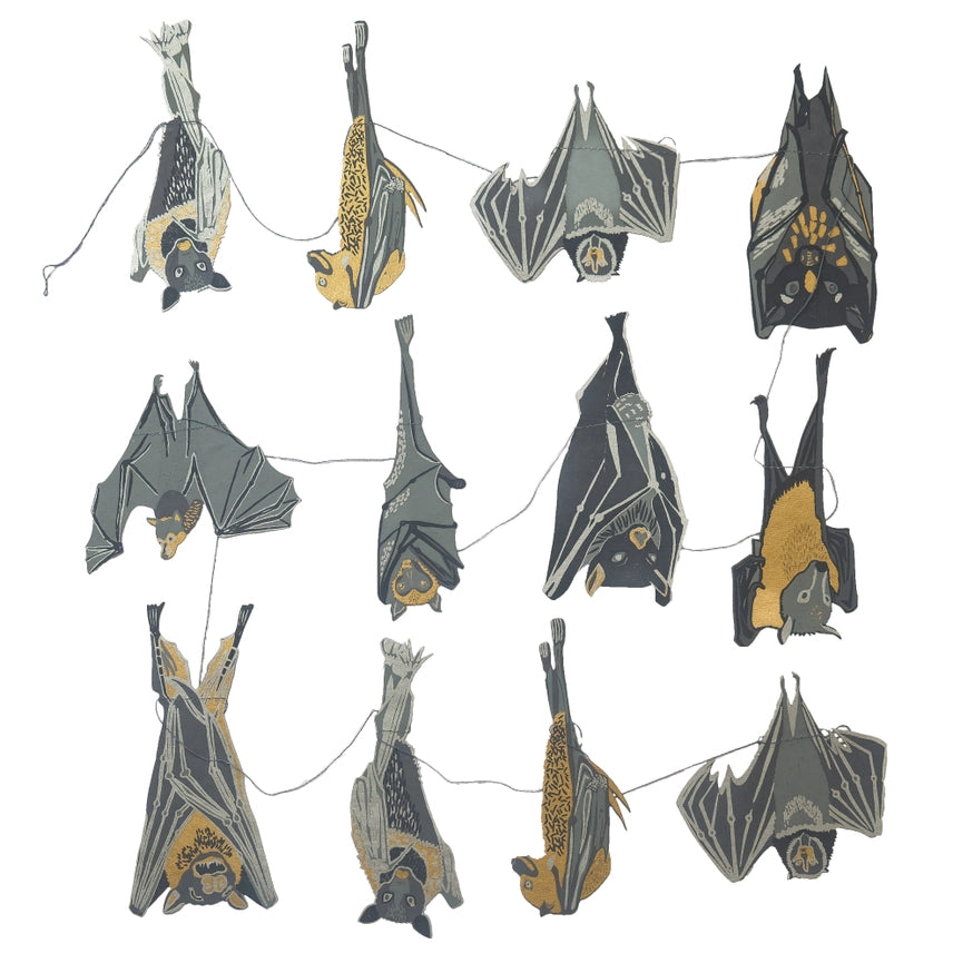 An image of hand screen printed bats that once hung are a decorative garland for halloween. There are lots of bats in different positions - some covered by their wings, others in a group hanging upside down. They are monochrome in colour.