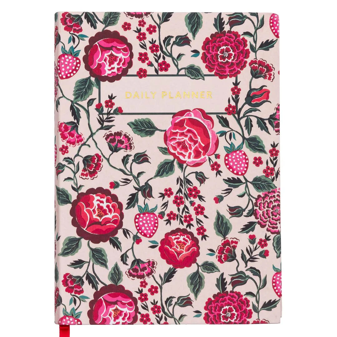 The front cover of a daily planner by Cath Kidston. The cover design has a cream background and is covered in colourful flowers and foliage in burgundy, pink and red. It also has red and pink strawberries dotted through the design. There are gold embellished words saying in capitals 'DAILY PLANNER'. 